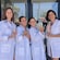 Guests in lab coats posing with perfume bottles outside the Tijon fragrance lab